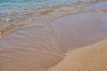 Clear waves on tropical sandy beach in Crete Greece.
