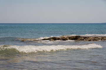 Waves with foam on Aegean sea coast in Crete Greece.