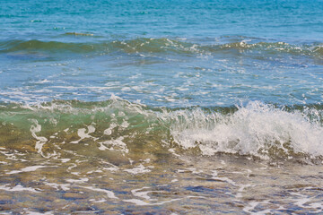 Waves with foam on Aegean sea coast in Crete Greece.
