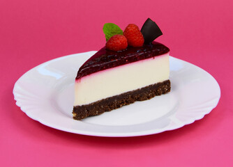 Slice of delicious creamy raspberry cake with jelly topping, raspberries and mint leaf stock images. Slice of cheesecake with raspberries isolated on a pink background stock photo