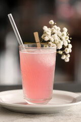Glasses with tasty cocktail and beautiful gypsophila flowers on table in room