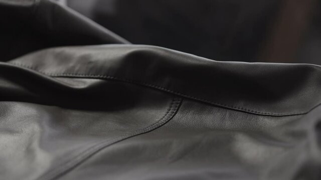 Slow motion closeup slide shot of soft gray brown leather jacket