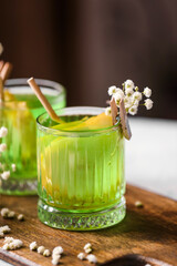 Glasses with tasty cocktail and beautiful gypsophila flowers on table