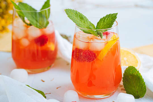 Cold drink. Orange drink with mint and fruits. Fresh drink in glass. Summer drink. Drink from beach bar.