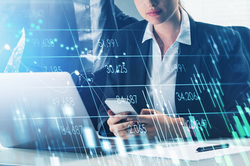 Businessman and businesswoman or stock traders analyzing stock data to apply new strategy to beat the market. Business people using laptop and smartphone, rates and candlesticks, internet trading