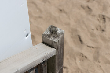 wooden hand rail near a sandy area