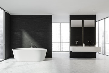 Obraz na płótnie Canvas White bathroom with panoramic windows behind black partitions and a bathtub