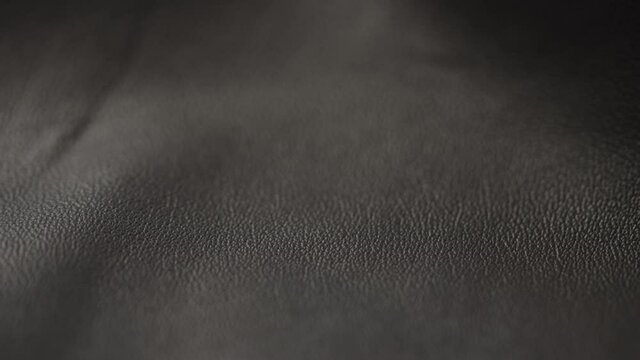 Slow motion closeup slide shot of soft gray brown leather