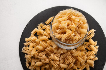 Italian quality uncooked durum wheat spiral pasta on light background top view