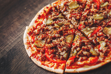 Pizza with Mozzarella cheese, minced meat and vegetables. Italian pizza on wooden background.