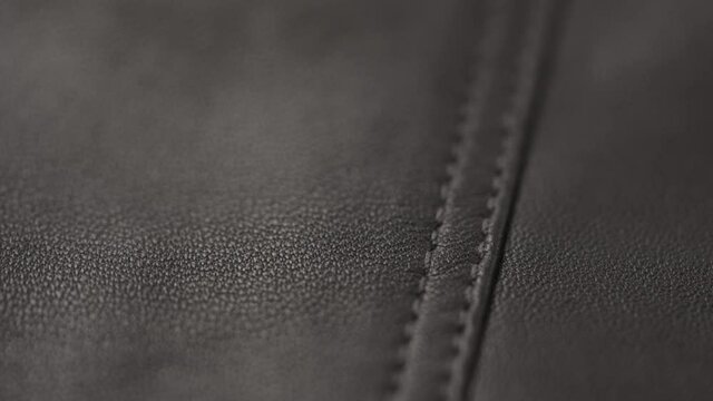 Slow motion closeup slide shot of soft gray brown leather