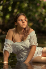 Naklejka premium woman with white dress near stream of water