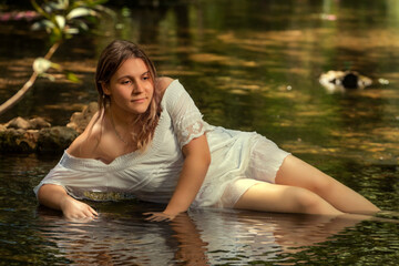 woman with white dress near stream of water