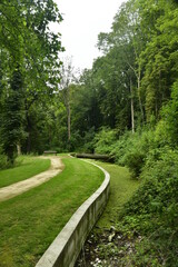 Chemin le long d'un bras d'eau étroit dans le bois du domaine des Trois Fontaines à Vilvoorde 