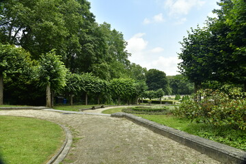 Fototapeta na wymiar chemin entre les pelouses et parterres de fleurs au jardin du parc des Trois Fontaines à Vilvoorde 