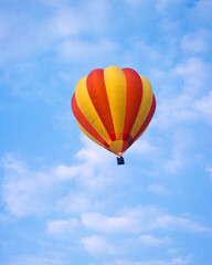 Fototapeta na wymiar Red and yellow hot air balloon in a blue sky