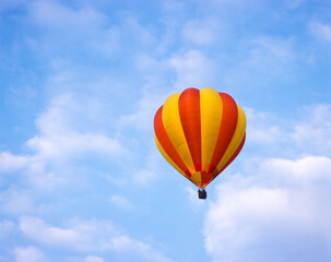Red and yellow hot air balloon in a blue sky