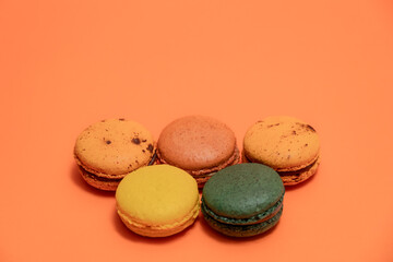 Fototapeta premium Close up of macaroons on an orange background