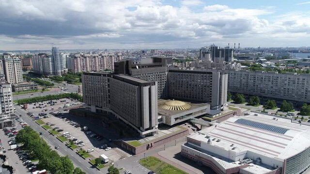 An air flight over St. Petersburg in the center of the frame is an old building in the style of Soviet constructivism with a golden roof. Sunny day and blue sky with big clouds