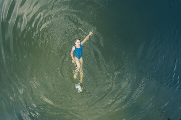 8 year girl swimming in the water on the back, and smiling.