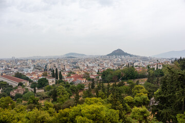 Fototapeta na wymiar View on mount Lycabettus and Athens old city center architecture in vivid greenery in gray foggy day from Areopagus - Hill near Acropolis