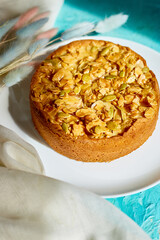 Apple or pear pie, tart with caramel nuts on blue table with sunlight
