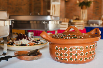 Salad and typical clay pot for buffet of traditional mexican food in Mexico
