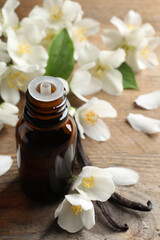 Obraz na płótnie Canvas Jasmine essential oil and fresh flowers on wooden table