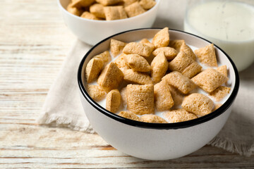 Tasty corn pads with milk served for breakfast on white wooden table, closeup