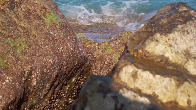blue sea water breaks against the rocks. Beautiful sea spray from stones