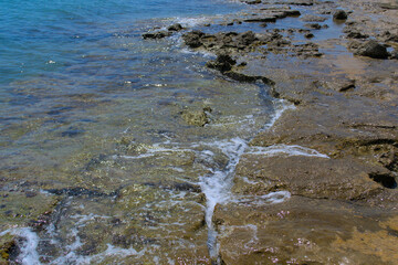 The rocky shore of the sea, the waves break on the stones.