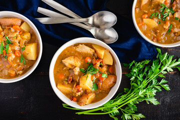 Chicken Stew with Potatoes and Carrots in a White Wine Broth: Bowls of fresh white wine chicken stew garnished with chopped parsley