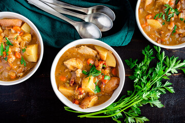Chicken Stew with Potatoes and Carrots in a White Wine Broth: Bowls of fresh white wine chicken stew garnished with chopped parsley