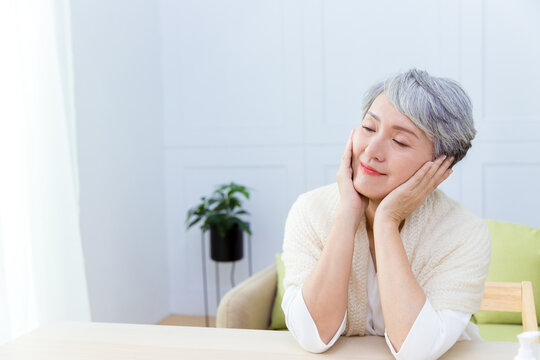 The beauty Senior Asian woman with grey hair enjoys doing skin care.