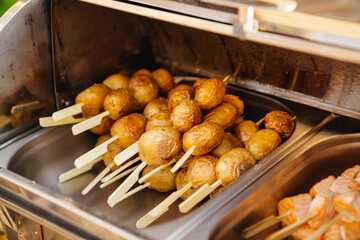 serving small hot kebabs from potatoes on the buffet. 