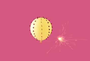 Yellow balloon with rose thorns and spark on pink background. Minimal surrealism.