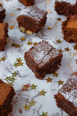 Brownie squares dusted with powdered sugar on a festive, light background. 