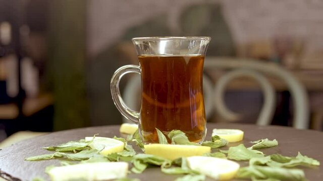 A cup of tea on a table. Hot drink.
Cup of tea with lemon and mint leaves 