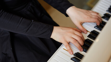 Obraz premium Womans hands on the keyboard of the piano closeup