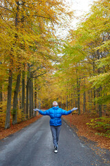 Young woman posing in the autumn forest on the road.