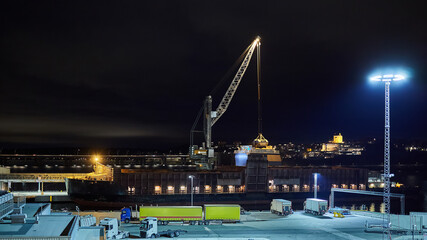 Fototapeta na wymiar mechanical hydraulic clamshell grabbers loading coal on ship at night.