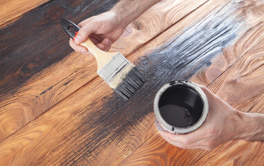 Fototapeta na wymiar Man painting wood with a brush.