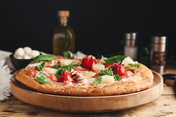 Pita pizza with prosciutto, pineapple, grilled tomatoes and egg on wooden table, closeup