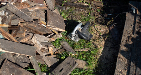 an electric manual circular saw lies near the sawn wood
