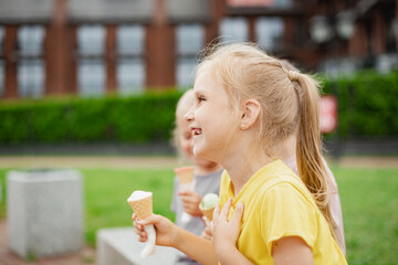 Three kids eating ice cream on hot summer day. Siblings walking outside and enjoying ice cream