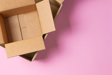 Empty open cardboard boxes on light pink background. Top view, copy space