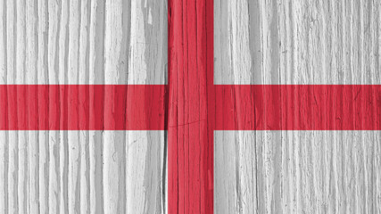 The flag of England on a dry wooden surface, cracked with age. It seems to flutter in the wind. Background, wallpaper or backdrop with national symbol. Saint George's Cross. Hard sunlight with shadows