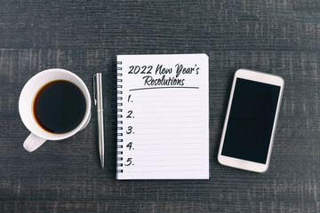 2022 New Year's Resolutions Text on Note Pad with smart phone and a cup of coffee