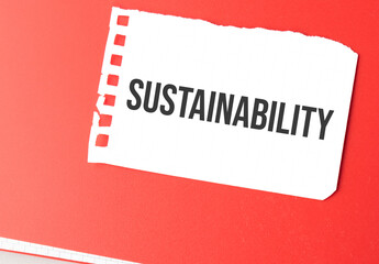 The word Sustainability on torn paper on red notepad,.