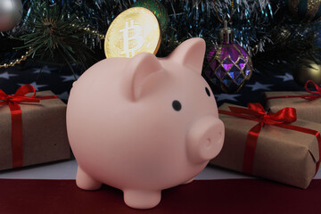 opening piggy bank pig with golden bitcoin under the christmas tree next to christmas gifts on the usa flag, close-u